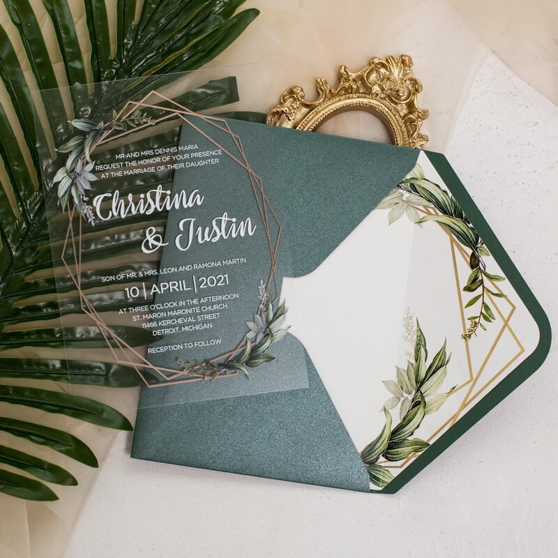 A wedding invitation for Christina and Justin, featuring elegant green and gold accents, surrounded by tropical leaves.